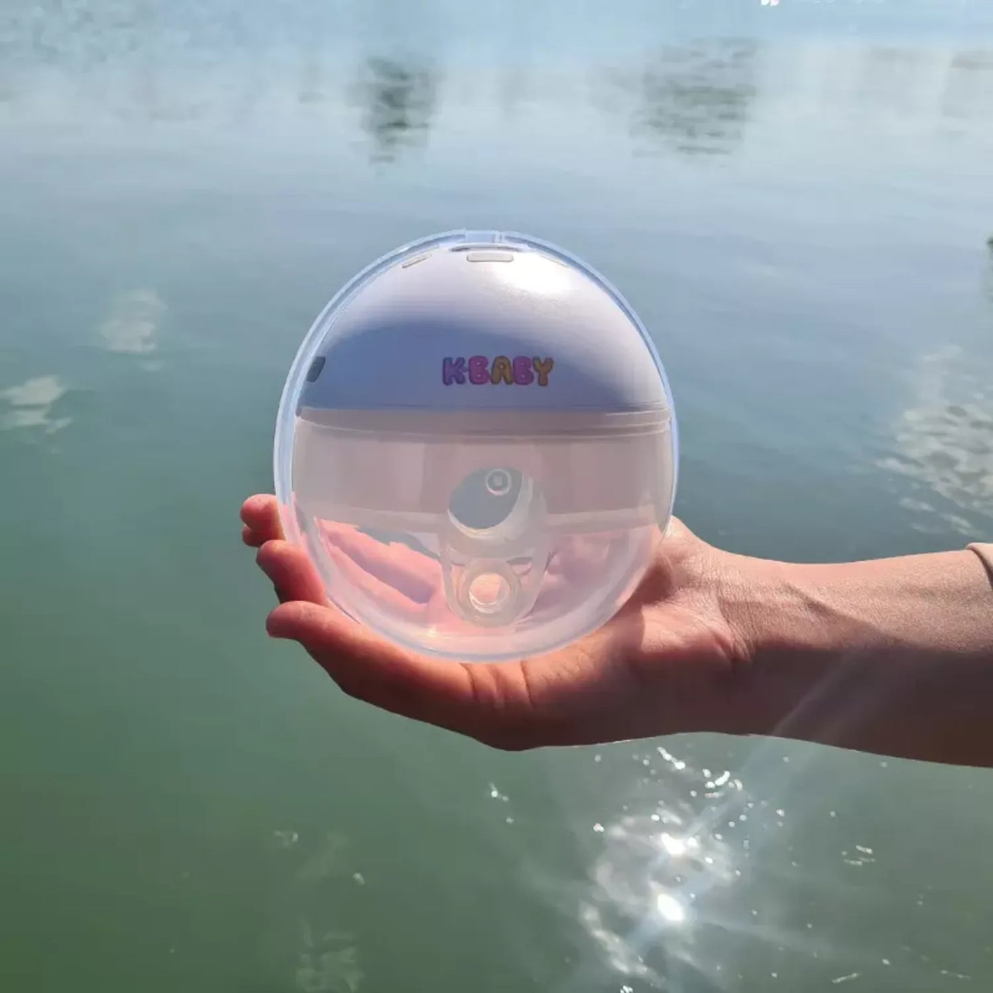 Tire-lait portable K-BABY tenu dans la main, design compact et nomade pour les mamans actives